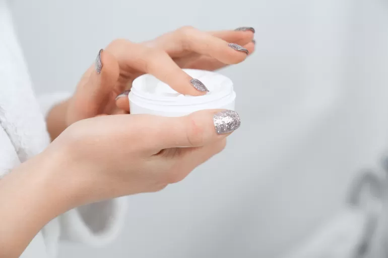 woman holding cream face body bathroom