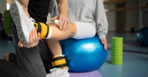 pacjent odbywajacy rehabilitacje ruchowa pod opieka terapeutow