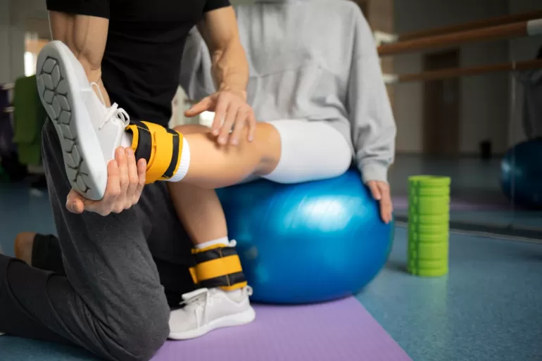 pacjent odbywajacy rehabilitacje ruchowa pod opieka terapeutow